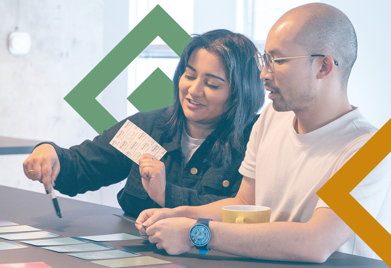 Two product leaders sitting down at a table to try out the Product Thinking Playbook card set 